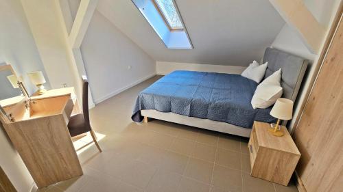 Un pequeño dormitorio con una cama azul y una ventana en Apartament Camping Portowy, en Mrzeżyno