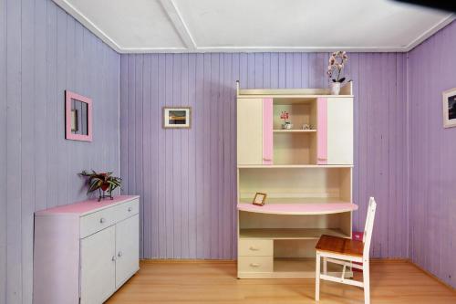 a purple room with a desk and a shelf at Ferienhaus beim Alenbrunnen in Münsingen