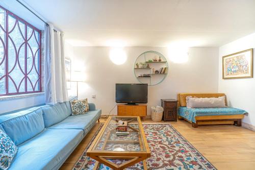 a living room with a blue couch and a tv at דירת מסע בגליל in Bet Leẖem HaGelilit
