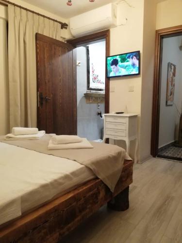 a bedroom with a bed and a desk and a television at ŞeydADA in Bozcaada