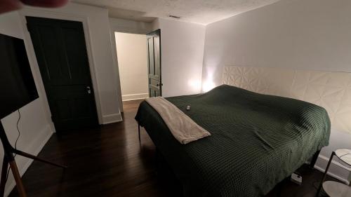 a bedroom with a bed with a green blanket at Rooftop GreeneHouse Suite in Philadelphia