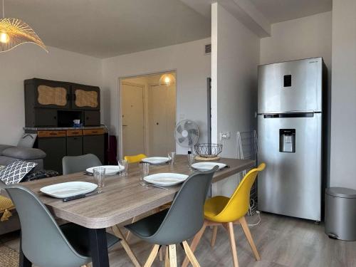 une cuisine avec une table avec des chaises et un réfrigérateur dans l'établissement Appartement 3 pièces 5 couchages BANYULS SUR MER BN050-H03, à Banyuls-sur-Mer