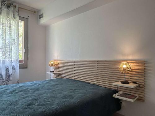 une chambre avec un lit et deux lampes et une fenêtre dans l'établissement Appartement 3 pièces 5 couchages BANYULS SUR MER BN050-H03, à Banyuls-sur-Mer