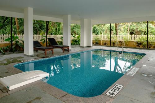 a swimming pool in a yard with at Nanu Beach Resort & Spa in Betalbatim