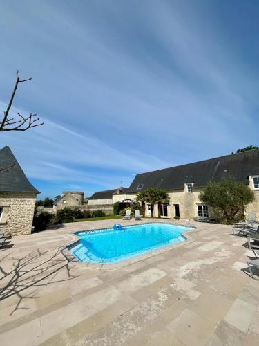 une piscine au milieu d'une cour dans l'établissement L'Aster, avec accès piscine et jacuzzi, à Saint-Côme-de-Fresné