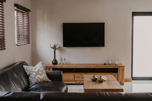 ムシナにあるSable Block Self-Cateringのソファと薄型テレビのあるリビングルーム