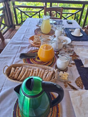 un tavolo con una teiera e bicchieri di succo d'arancia di Résidences-Bel-R a Nosy Be
