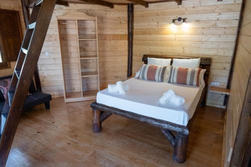 Un dormitorio con una cama en una cabaña de troncos en Cabaña Sudafrica, en Tarifa