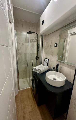 une salle de bain avec un lavabo et une douche dans l'établissement Chez LauLau, à Menton