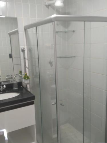 a bathroom with a glass shower and a sink at Victory Flat Intermares in Cabedelo