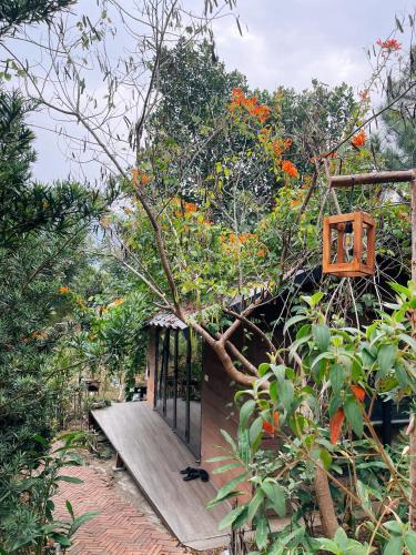 a tree house with a wooden bench in the forest at Căn Gỗ in Sóc Sơn
