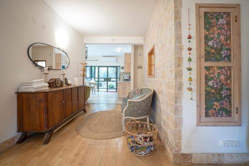 a living room with a mirror and a stone wall at דירת מסע בגליל in Bet Leẖem HaGelilit