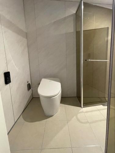 a bathroom with a toilet and a glass shower at Pillowsopher Hongdae in Seoul