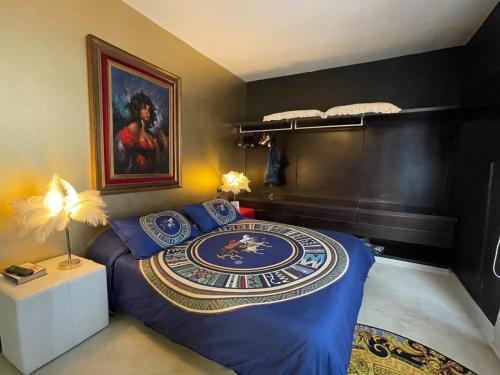 a bedroom with a blue bed with a painting on the wall at Mini piscina idromassaggio giardino e vista a mare in Tencarola