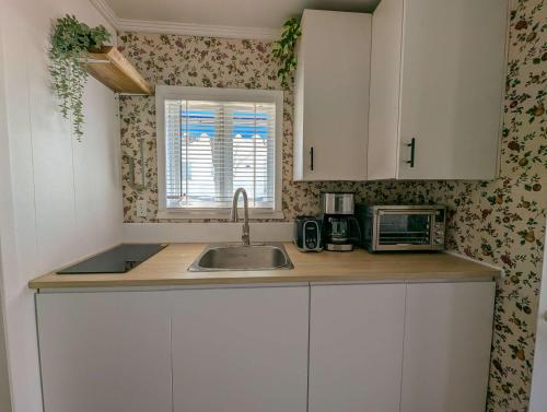 a kitchen with white cabinets and a sink and a window at Chalet Loft #4 Waterfront with Spa Fireplace and Wifi in Cap-Saint-Ignace