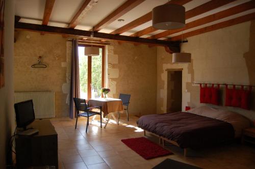 a bedroom with a bed and a table and a window at Haras des Hayes in Tresson