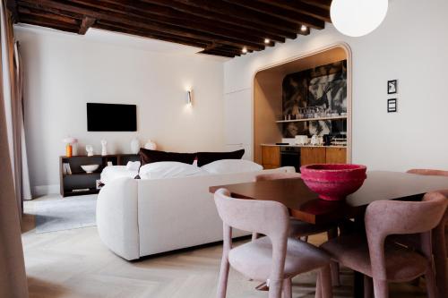 un salon avec un canapé blanc et une table dans l'établissement Babylon Marais, à Paris