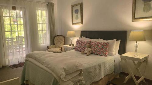a teddy bear sitting on a bed in a bedroom at Green Gables Guest House in Upington
