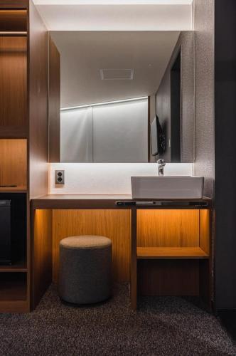 a bathroom with a sink and a stool at Pillowsopher Hongdae in Seoul