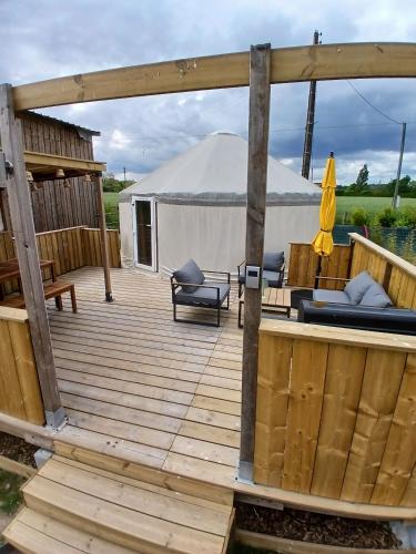 une terrasse en bois avec une tente en arrière-plan dans l'établissement Yourte- Bambou - Climatisée- Les Belles Ouvrières, à Clermont-Créans