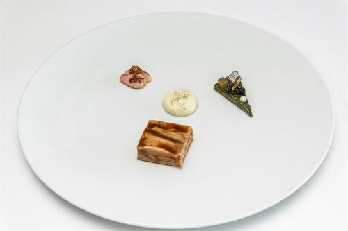 a white plate with some food on it at Hotel Emporium - Adults Only in Castelló d'Empúries