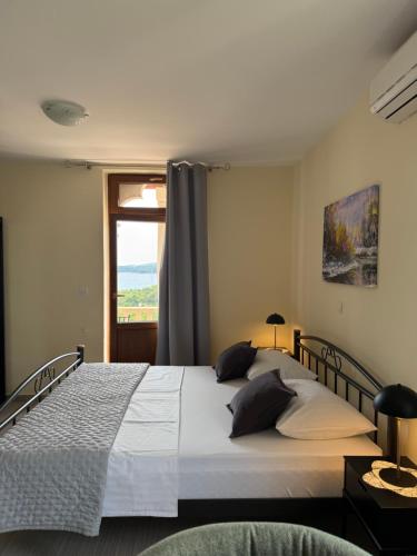 a bedroom with a large bed and a window at Apartments Villa Dinka in Hvar