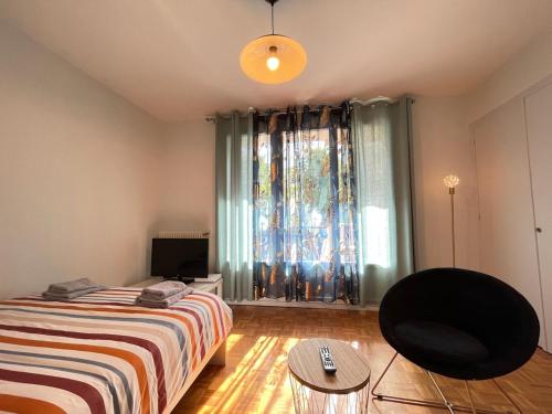 une chambre avec un lit, une chaise et une fenêtre dans l'établissement Le Cocon Annécien, à Annecy