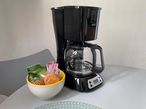 une cafetière noire à côté d'un bol de nourriture dans l'établissement Le Cocon Annécien, à Annecy