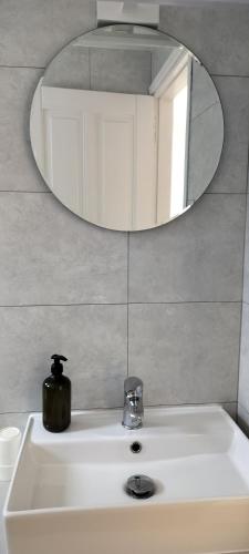 a bathroom with a sink and a mirror at Raisakis Apartments in Agia Marina Nea Kydonias