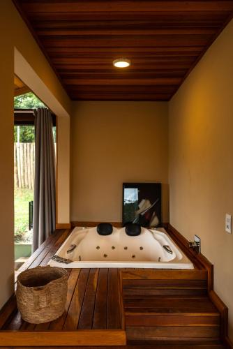 a bath tub in a room with a wooden floor at Meu Limão Meu Limoeiro in Visconde De Maua