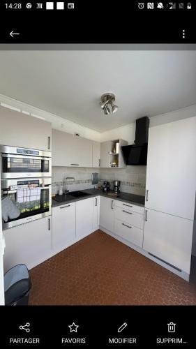 une cuisine blanche avec des armoires et des appareils blancs dans l'établissement Your 28 m Studio Near Paris Modern Convenient and Affordable, à Fontenay-aux-Roses