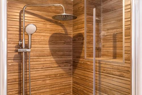a bathroom with a shower with wooden walls at Yvonne in Krk