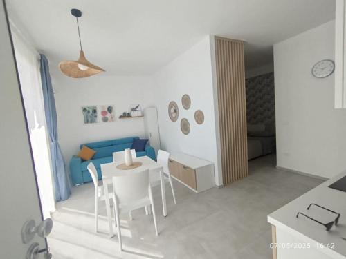 a living room with a table and chairs and a blue couch at Il sogno di Giò in Portopalo