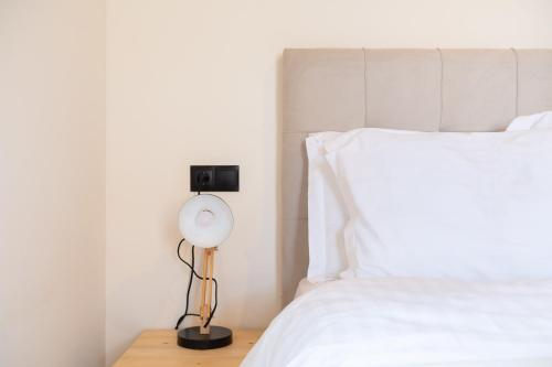 a bedroom with a white bed and a lamp at Mani view luxury house in Agios Nikolaos