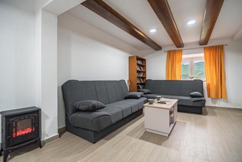 a living room with a couch and a fireplace at Arija Stone House - Rural Studio Apartment in Nikšić