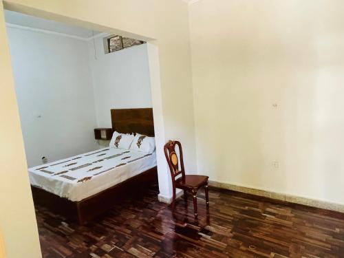 a bedroom with a bed and a chair in it at Bete Selam in Bahir Dar