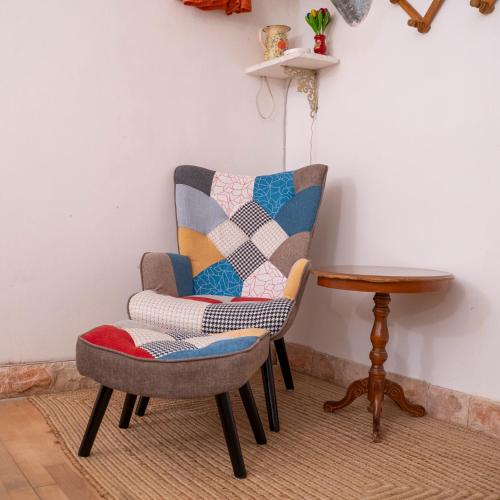 a chair with a quilt on it next to a table at דירת מסע בגליל in Bet Leẖem HaGelilit