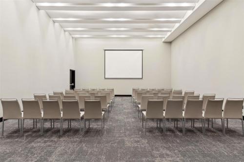 an empty room with chairs and a white wall at NH Collection Monterrey San Pedro in Monterrey