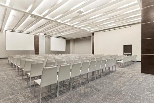 an empty conference room with chairs and a screen at NH Collection Monterrey San Pedro in Monterrey