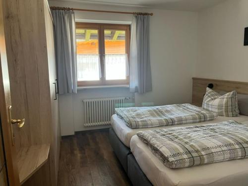 two beds in a room with a window at Ferienwohnung Pauliner in Oberstdorf
