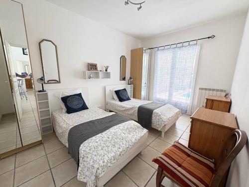 une chambre avec deux lits et un miroir dans l'établissement Élégante villa moderne à deux pas de la plage - FR-1-831-7, à Biscarrosse