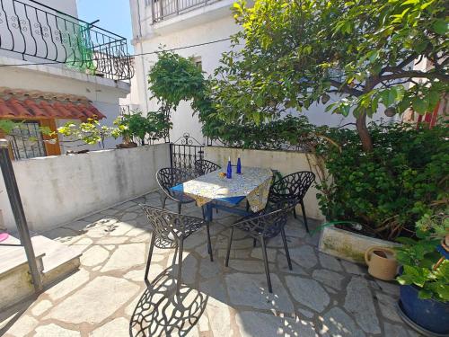 a table and chairs sitting on a patio at Louloudi, charming townhouse in Skiathos Town