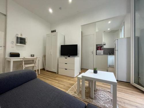 un salon avec un canapé, une table et une télévision dans l'établissement Studio Climatisé Coeur Nice, à Nice
