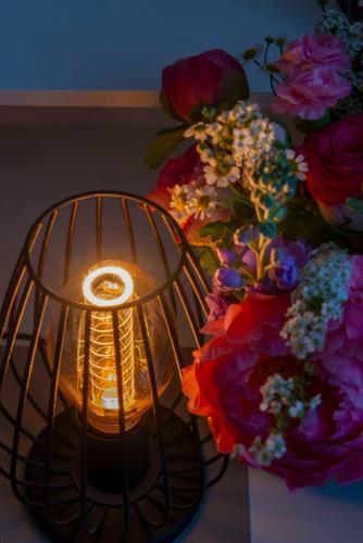 a candle in a cage next to a bouquet of flowers at Hotel Alte Post in Krefeld