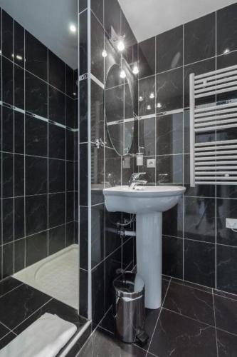 La salle de bains est pourvue de carrelage noir, d'un lavabo et d'une douche. dans l'établissement BRISTOL PARK AP4467 by Riviera Holiday Homes, à Cannes