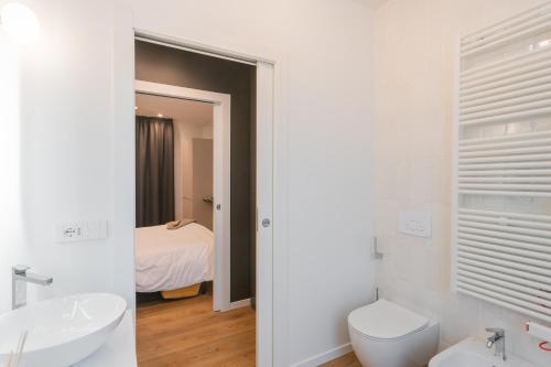 a white bathroom with a toilet and a sink at Rezia Apartments by Rent All Como in Como