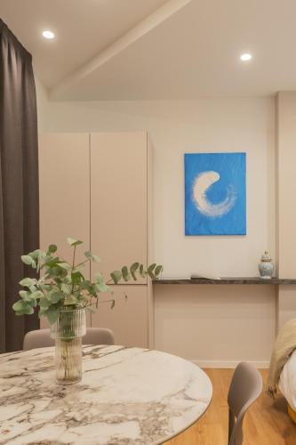 a dining room with a table with a vase on it at Rezia Apartments by Rent All Como in Como