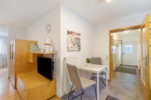 a living room with a dining room table and a television at Ferienwohnung Emilia, 36qm in Münsingen