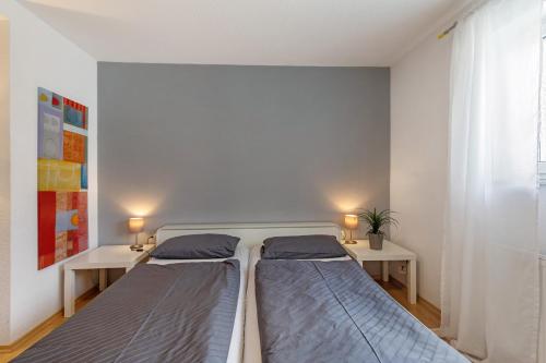 two beds in a room with two tables at Ferienwohnung Emilia, 36qm in Münsingen