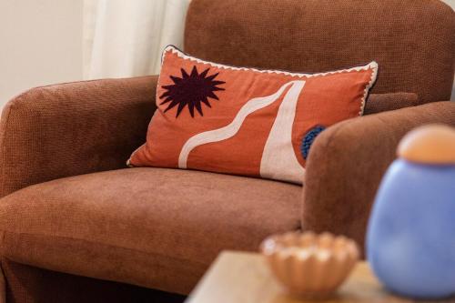 a brown chair with a pillow on a table at The Holkham Uno - One Bed Apartment Fairy Bower in Sydney
